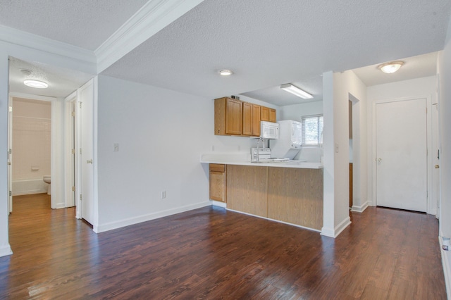 kitchen featuring ornamental molding, kitchen peninsula, white appliances, a textured ceiling, and dark hardwood / wood-style floors