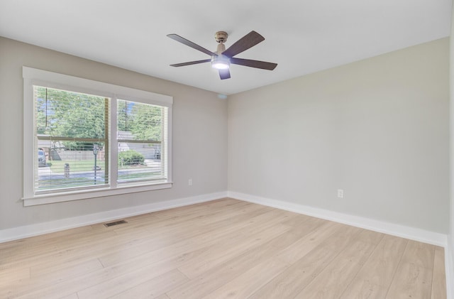 spare room featuring light wood-style flooring, baseboards, and ceiling fan
