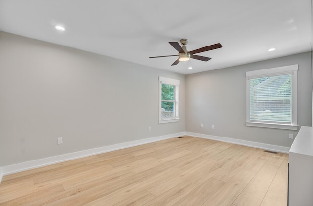 spare room with a ceiling fan, light wood-type flooring, plenty of natural light, recessed lighting, and baseboards