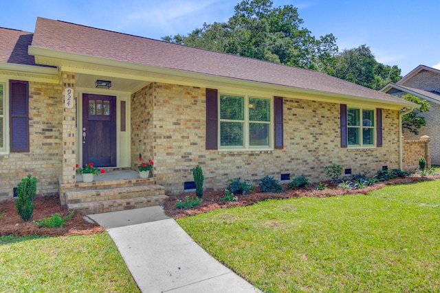 view of front of property featuring crawl space, a front lawn, brick siding, and roof with shingles
