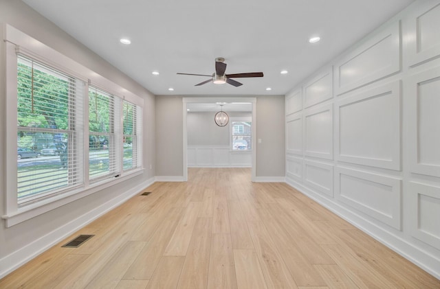 unfurnished living room featuring light wood finished floors, a ceiling fan, healthy amount of natural light, baseboards, and recessed lighting