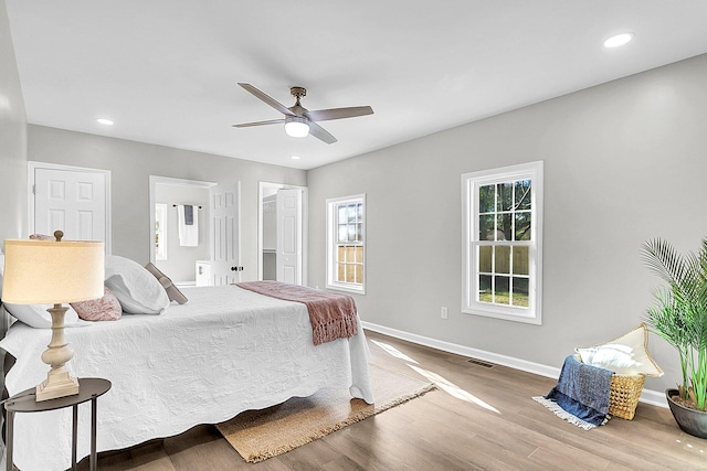 bedroom with a closet, a walk in closet, hardwood / wood-style flooring, and ceiling fan