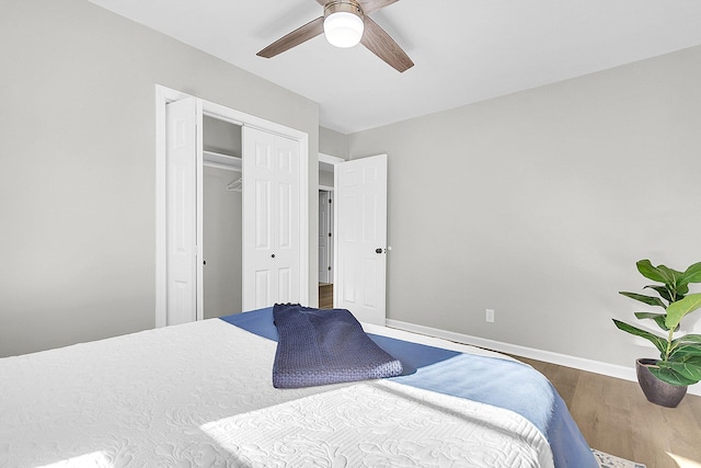 bedroom with ceiling fan, wood-type flooring, and a closet