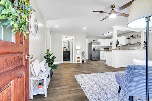 living room featuring dark hardwood / wood-style floors, ceiling fan, and sink