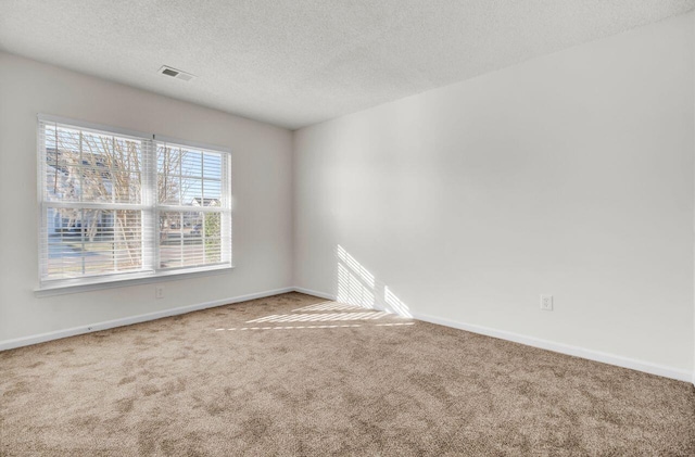 carpeted empty room with a textured ceiling