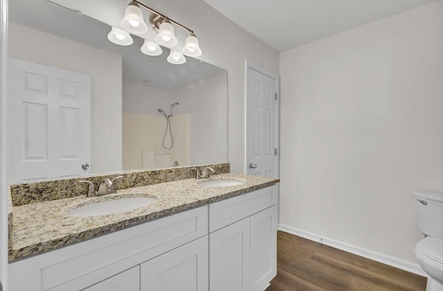 bathroom with hardwood / wood-style flooring, a shower, vanity, and toilet