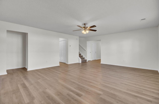 unfurnished living room with ceiling fan, a textured ceiling, and light hardwood / wood-style floors