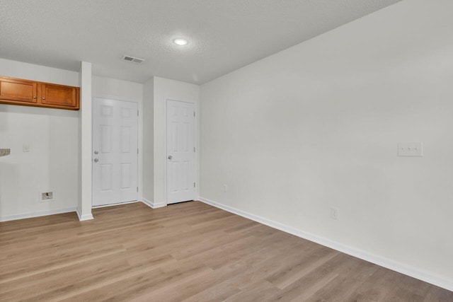 interior space featuring a textured ceiling and light wood-type flooring