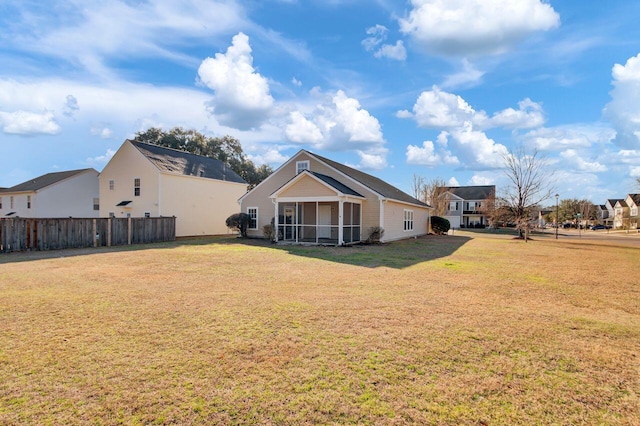 back of house with a yard and a sunroom