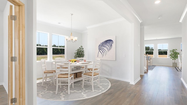 dining room featuring dark hardwood / wood-style flooring, an inviting chandelier, and crown molding