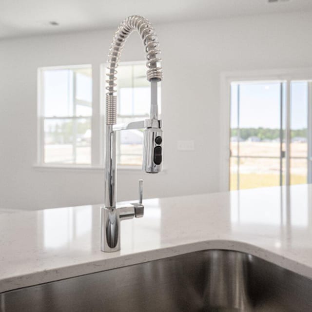 details featuring light stone countertops and sink