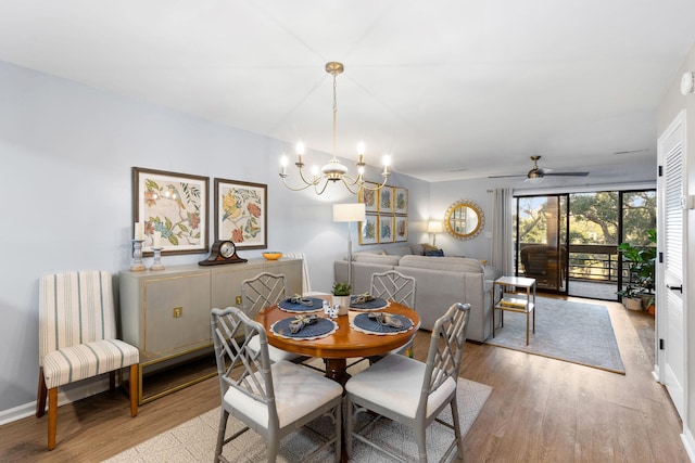 dining space featuring light hardwood / wood-style floors and ceiling fan with notable chandelier