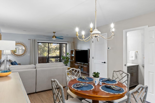 dining area featuring light hardwood / wood-style flooring and ceiling fan with notable chandelier