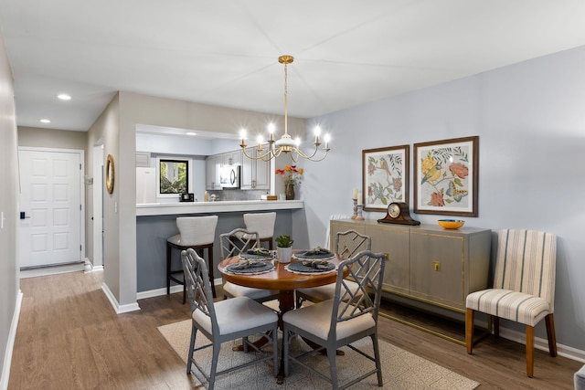 dining area featuring hardwood / wood-style flooring and a chandelier