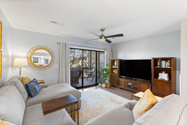 living room featuring wood-type flooring and ceiling fan