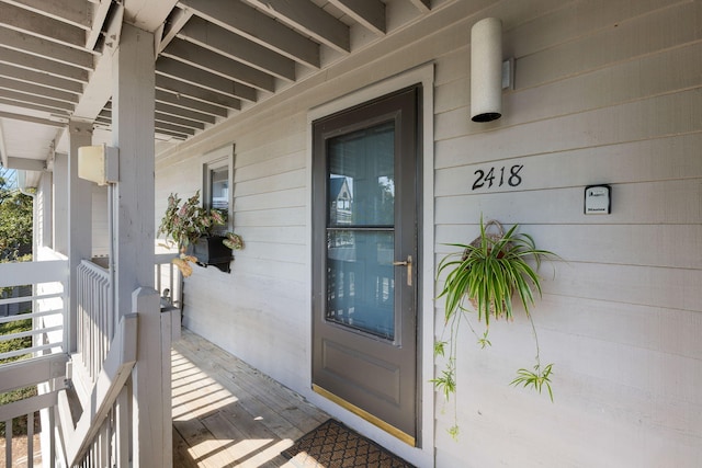 view of exterior entry featuring covered porch