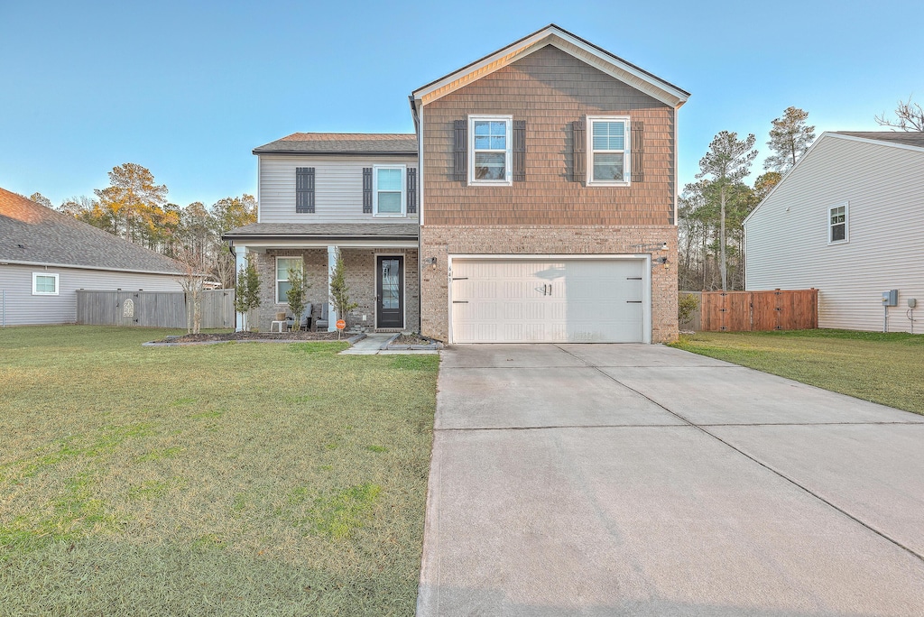 view of front property featuring a front yard, a garage, and a porch