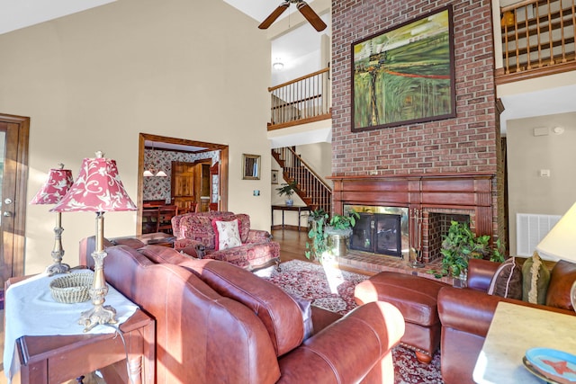 living room featuring hardwood / wood-style floors, high vaulted ceiling, a fireplace, and ceiling fan