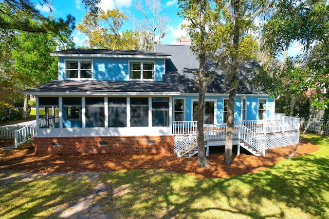 view of front of house featuring a sunroom and a front lawn