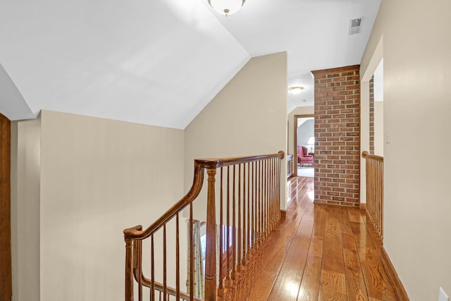 corridor with lofted ceiling and hardwood / wood-style flooring