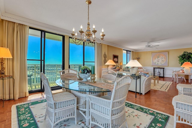 dining room featuring parquet flooring, ornamental molding, and ceiling fan with notable chandelier