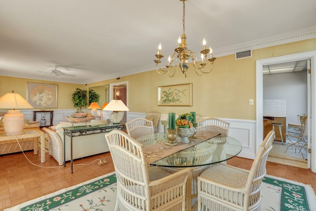 dining room featuring crown molding, parquet floors, and ceiling fan with notable chandelier