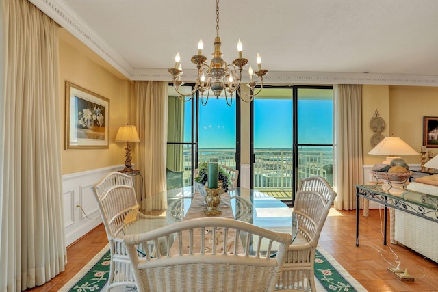 dining space with parquet flooring, crown molding, and a notable chandelier