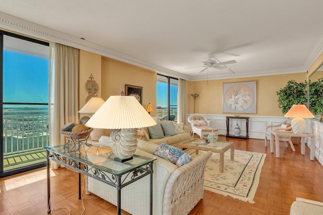 living room with parquet flooring, ornamental molding, and ceiling fan