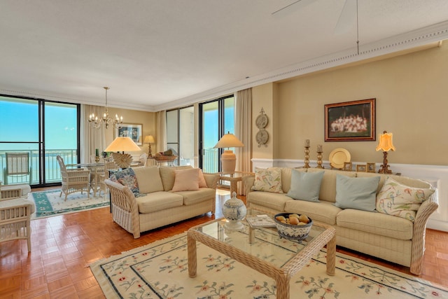 living room featuring parquet floors, ornamental molding, a chandelier, and expansive windows