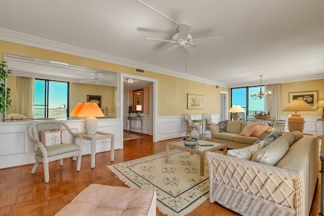 living room with parquet flooring, crown molding, and ceiling fan with notable chandelier