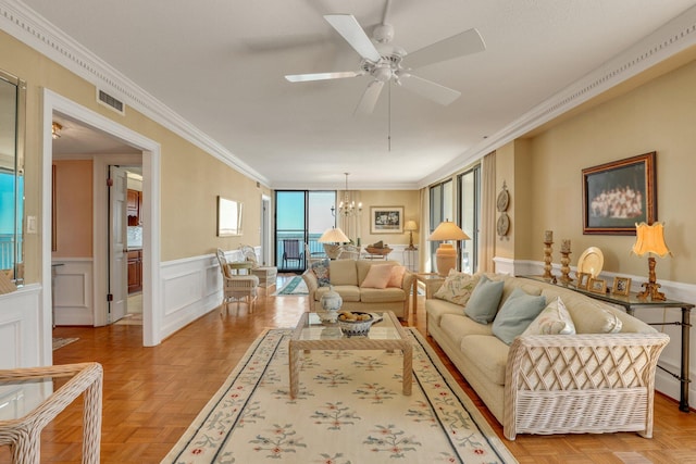 living room featuring ornamental molding, baseboard heating, light parquet flooring, and ceiling fan with notable chandelier