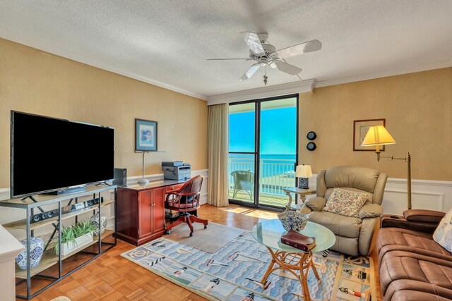 living room featuring ceiling fan, a textured ceiling, light parquet flooring, ornamental molding, and a water view