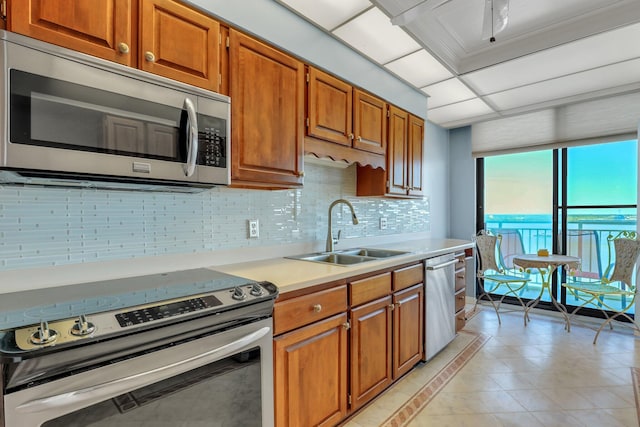 kitchen with light tile patterned floors, tasteful backsplash, appliances with stainless steel finishes, and sink