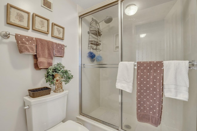 bathroom with toilet and a shower with shower door