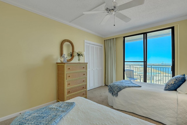 bedroom with carpet floors, access to exterior, a closet, ceiling fan, and ornamental molding