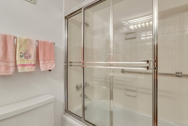 bathroom featuring shower / bath combination with glass door and toilet