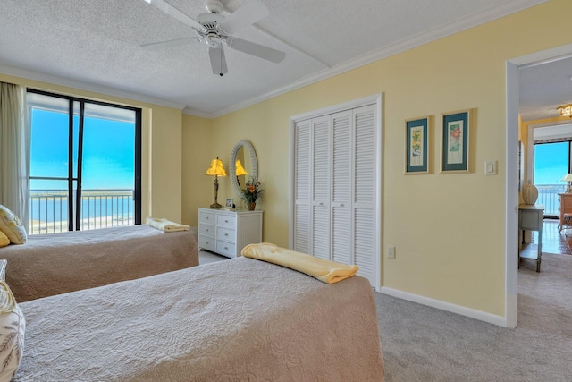 bedroom featuring light carpet, ceiling fan, access to exterior, a closet, and a water view