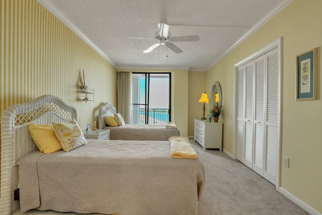 carpeted bedroom featuring ceiling fan, a textured ceiling, access to exterior, ornamental molding, and a closet