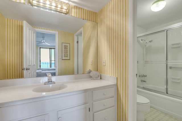 full bathroom with vanity, toilet, combined bath / shower with glass door, and ceiling fan