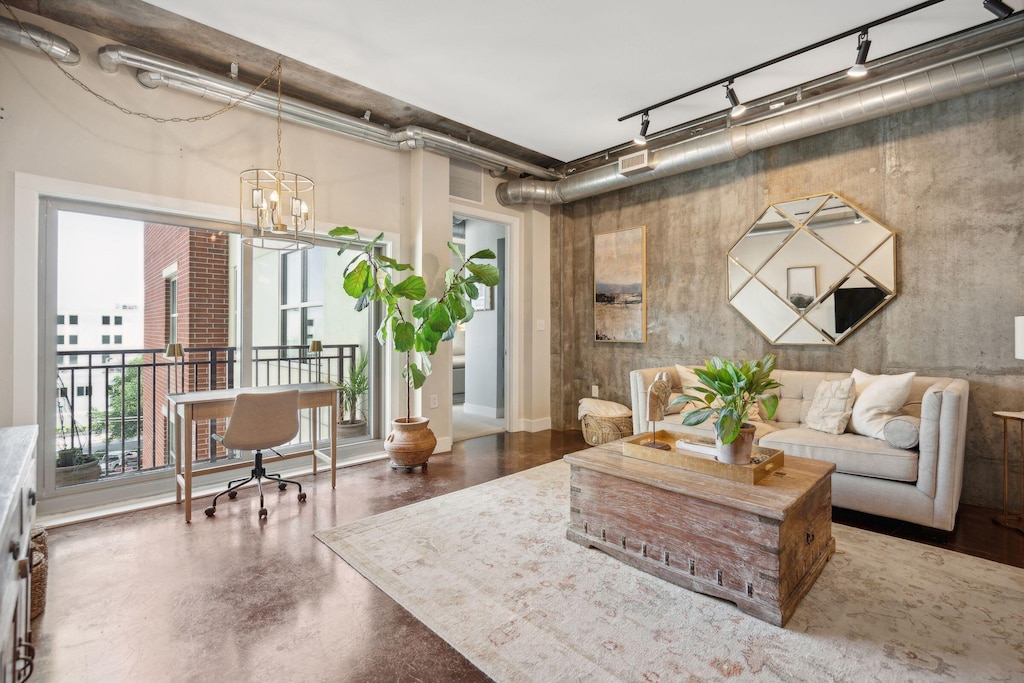 living room featuring concrete flooring and a chandelier