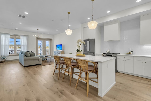 kitchen with a breakfast bar, white cabinetry, stainless steel appliances, and a kitchen island