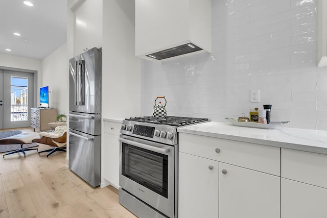 kitchen with premium range hood, stainless steel appliances, decorative backsplash, french doors, and white cabinets