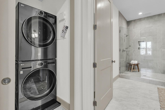 clothes washing area with stacked washing maching and dryer