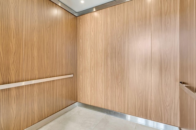 interior space with light tile patterned floors and elevator