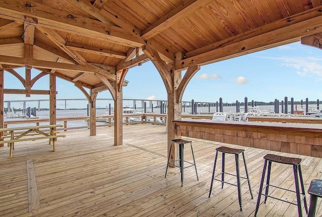 wooden deck featuring an outdoor bar and a water view