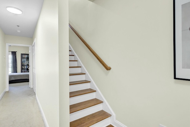 stairs featuring carpet and baseboards