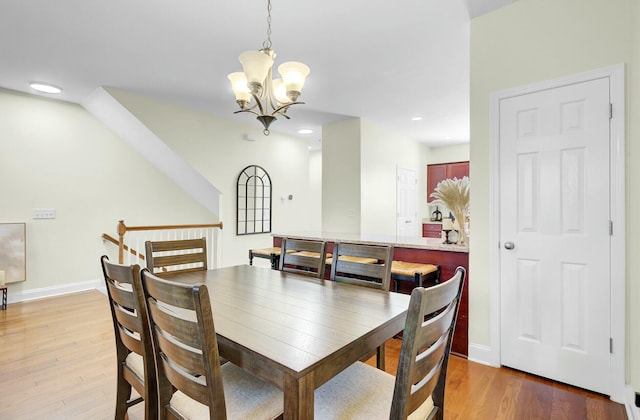 dining room with light wood-type flooring, an inviting chandelier, baseboards, and recessed lighting