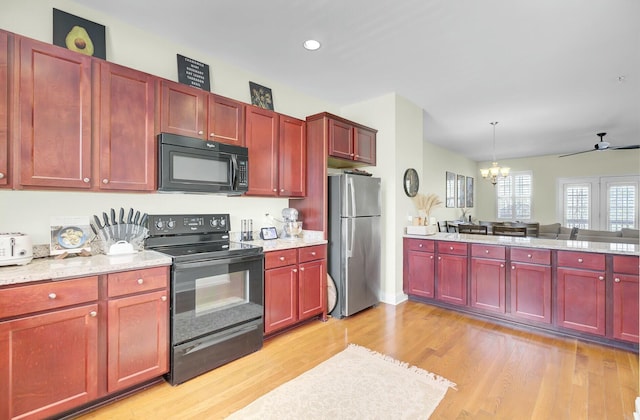 kitchen with dark brown cabinets, light wood finished floors, and black appliances