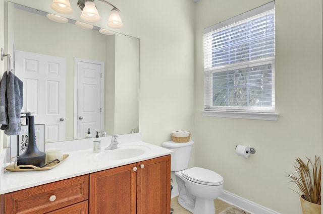 bathroom with toilet, tile patterned flooring, baseboards, and vanity