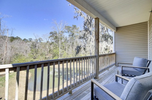 wooden terrace featuring a wooded view